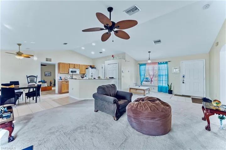 Living room featuring light tile patterned flooring, visible vents, and ceiling fan