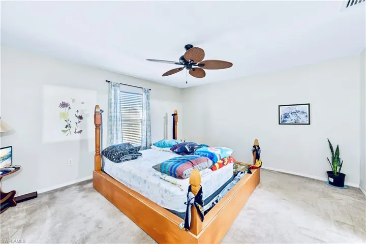 Bedroom featuring carpet flooring, baseboards, visible vents, and ceiling fan