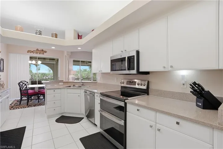 Bright kitchen features stainless steel appliances.