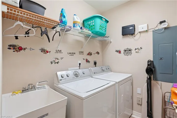 Convenient laundry room with utility sink and additional storage space.