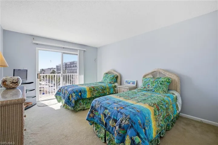 Carpeted bedroom with a textured ceiling and access to exterior