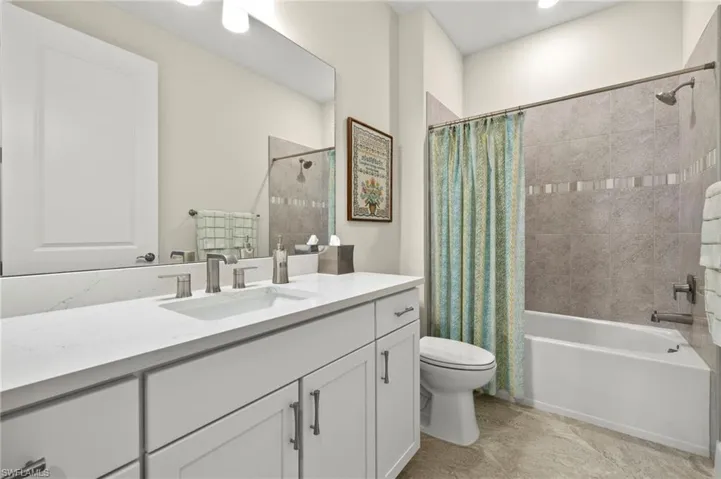 Full bath featuring toilet, shower / tub combo with curtain, and vanity