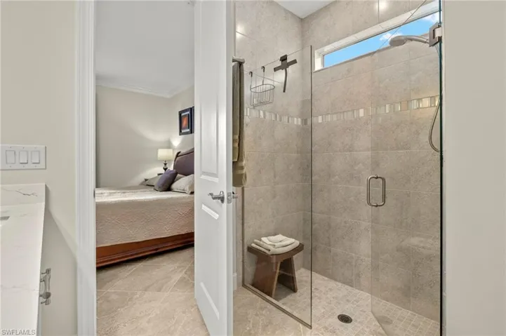 Ensuite bathroom featuring a stall shower, crown molding, connected bathroom, and tile patterned flooring