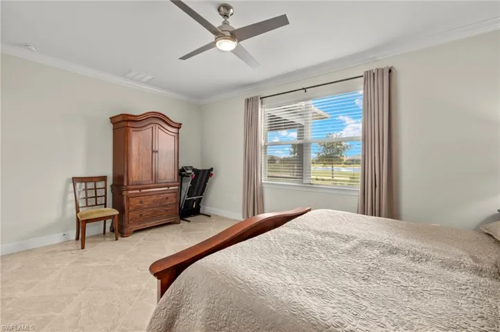 Bedroom featuring baseboards, ceiling fan, ornamental molding, and visible vents