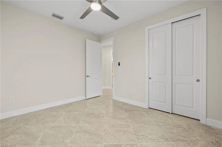 Unfurnished bedroom featuring baseboards, a closet, visible vents, and a ceiling fan