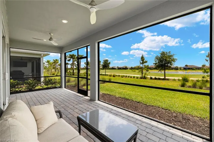 Sunroom with outdoor lounge area, view of golf course, and a ceiling fan