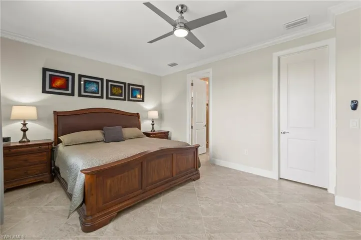 Bedroom featuring crown molding, visible vents, and baseboards