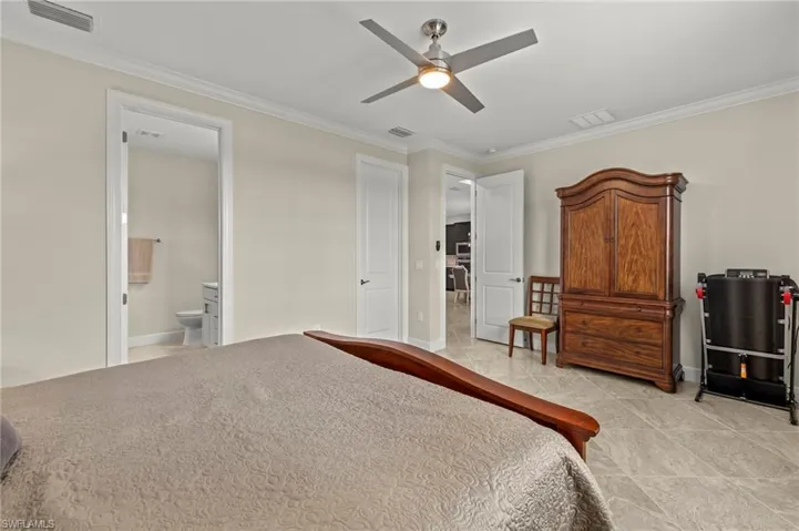 Bedroom featuring crown molding, visible vents, and baseboards