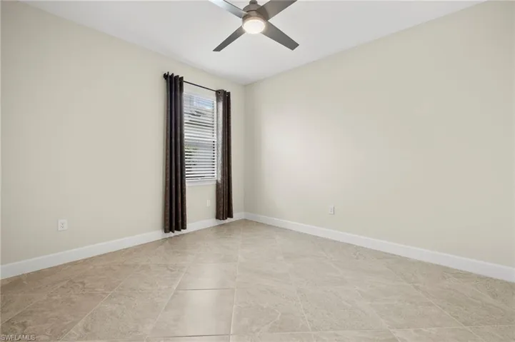 Spare room featuring baseboards and ceiling fan