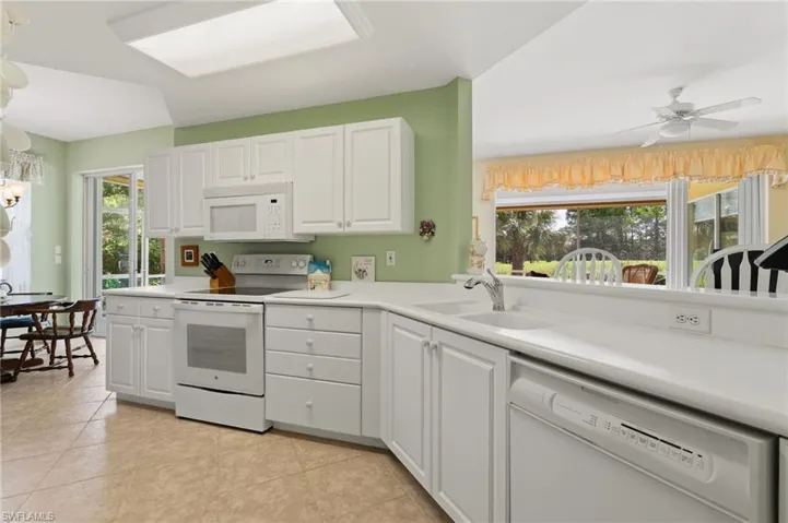 White and bright kichen features eat in area and breakfast bar