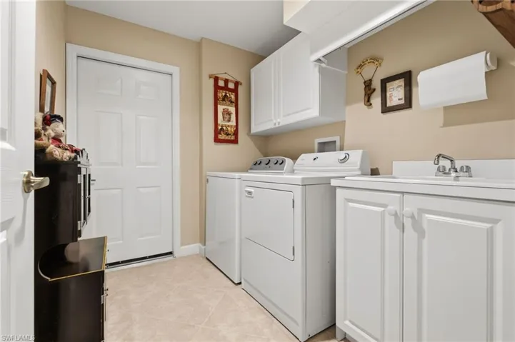 Laundry room with lots of cabinet storage, and laundry sink.