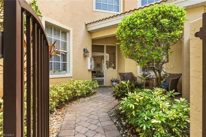 Private courtyard entrance with seating - one of few units with this feature. Retracting door screen allows for cross breeze  throughout the home.