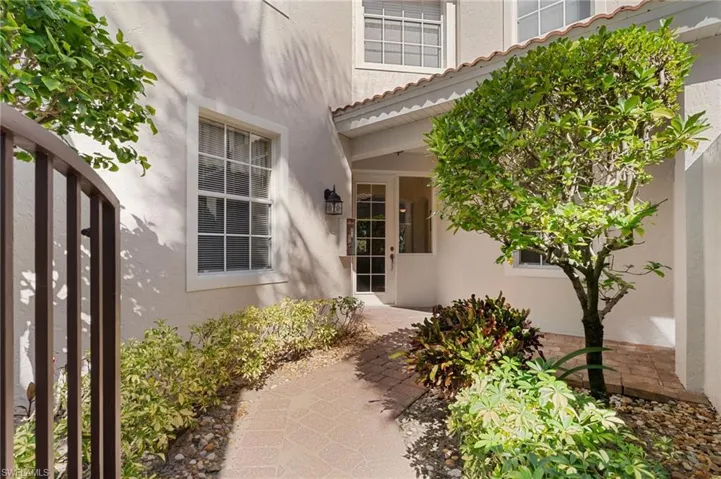Private courtyard entrance with seating - one of few units with this feature. Retracting door screen allows for cross breeze  throughout the home.