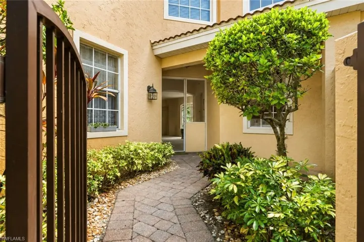 Private courtyard entrance with seating - one of few units with this feature. Retracting door screen allows for cross breeze  throughout the home.