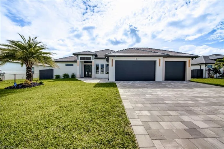 Modern Costal house featuring an attached garage, decorative driveway, stucco siding, and a tiled roof