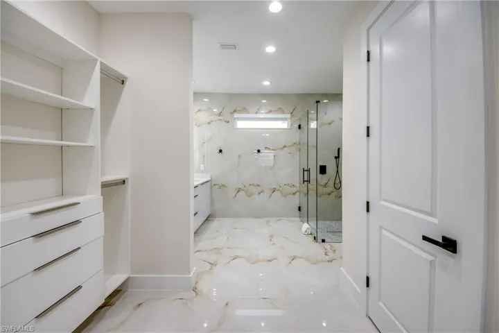 Walk-in closet with built-in shelving and drawer storage