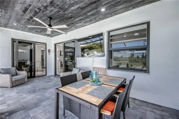 Covered patio featuring an exposed wood-finish plank ceiling, recessed lighting, a ceiling fan, and large format paver flooring