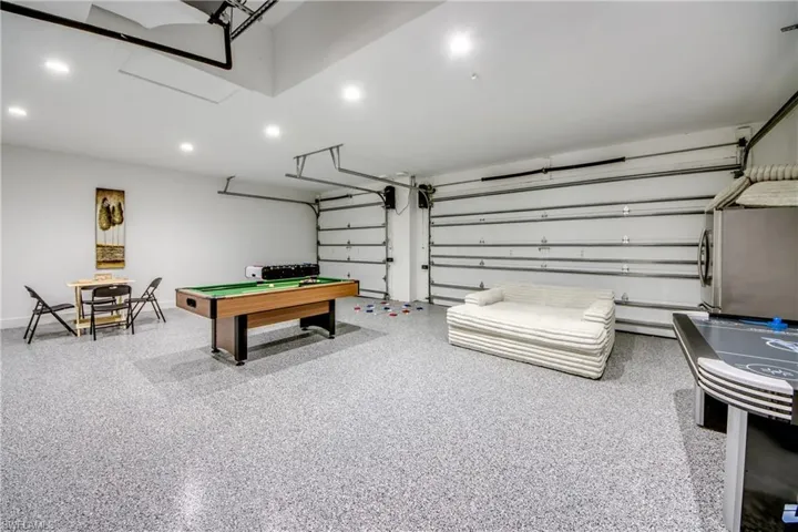 Spacious garage with epoxy flooring, recessed lighting, and white walls