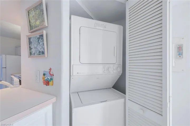Clothes washing area with stacked washing maching and dryer and laundry area
