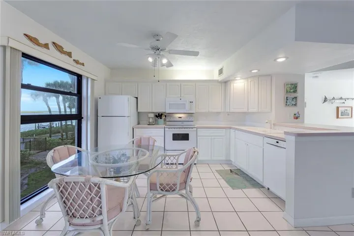 Kitchen featuring white appliances, light countertops, a sink, and light tile patterned floors