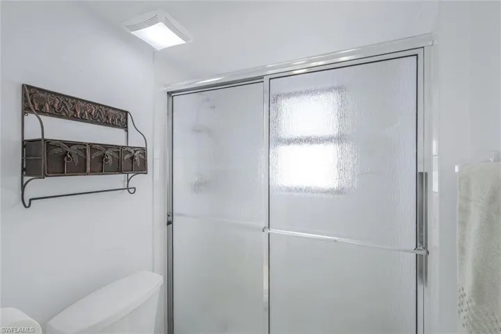 Full bath featuring a stall shower and toilet