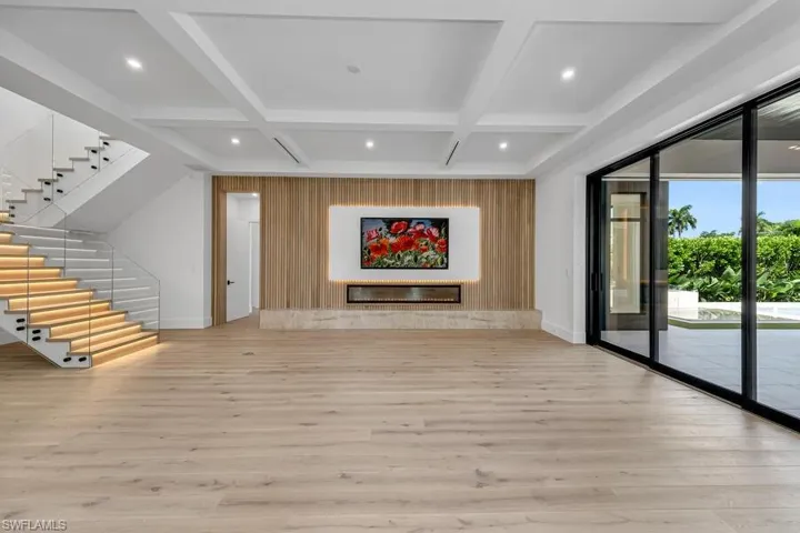 Unfurnished living room featuring light hardwood / wood-style floors and coffered ceiling