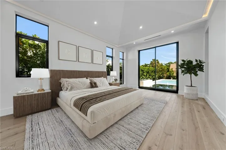 Bedroom featuring light wood-style floors, access to exterior, high vaulted ceiling, and recessed lighting