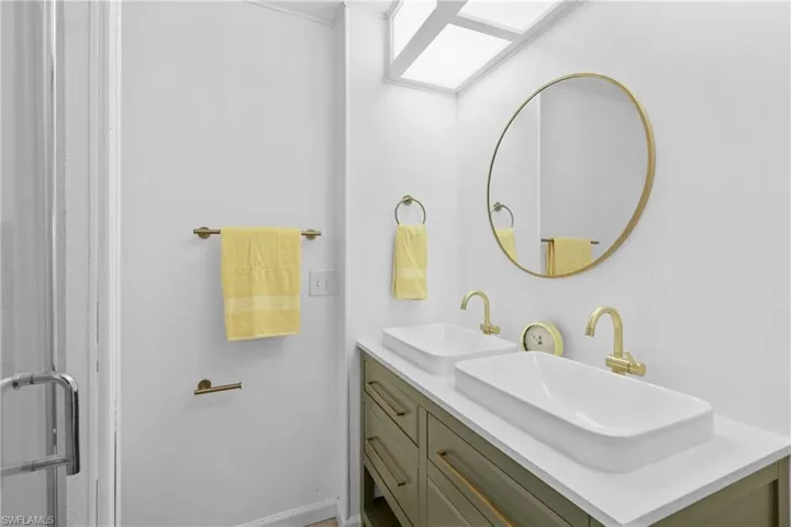 Full bathroom with double vanity and baseboards