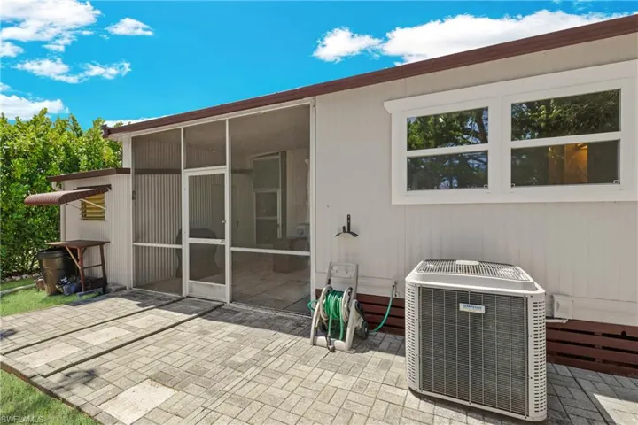 Rear view of house featuring a patio, central AC, and a sunroom