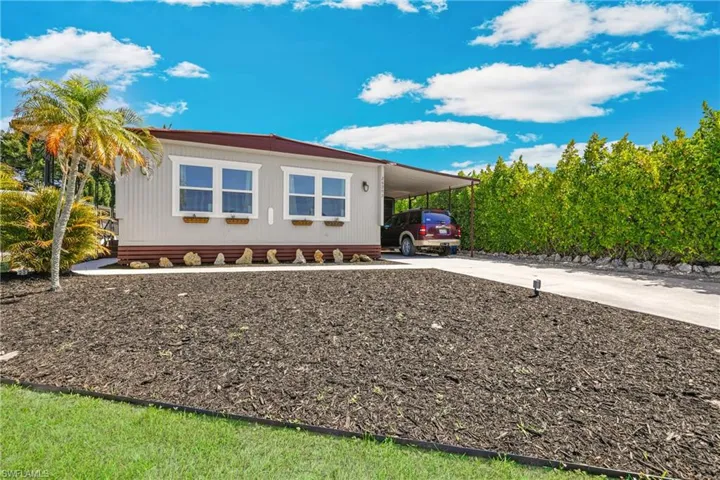 View of home's exterior featuring concrete driveway and an attached carport