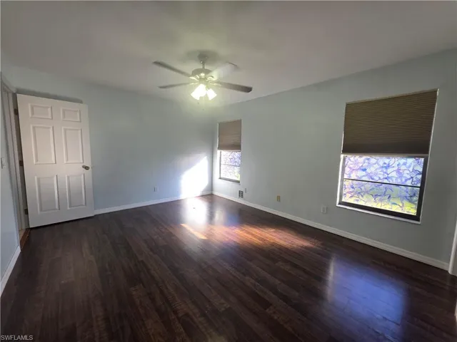 Spare room featuring dark wood-style floors and a ceiling fan