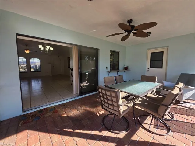 Wooden deck with outdoor dining space, a patio area, and a ceiling fan