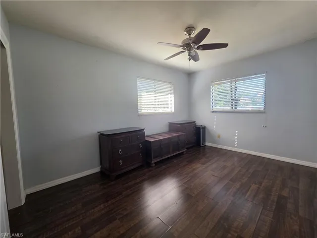 Unfurnished bedroom featuring dark wood-style floors and ceiling fan