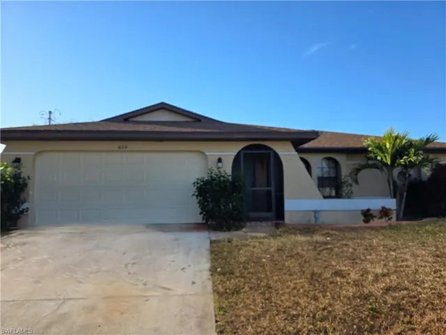 Ranch-style house with stucco siding, concrete driveway, a garage, and a front yard