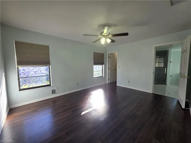 Unfurnished bedroom featuring a ceiling fan and dark wood-type flooring