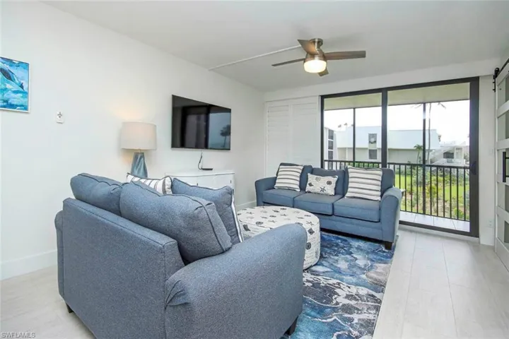 Living area featuring baseboards and ceiling fan