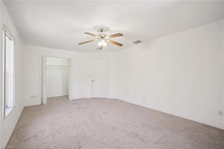 Other view of bedroom 2 with light carpet, a ceiling fan, and a closet