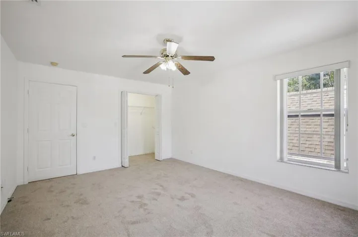 Other view of bedroom 3 with light carpet, ceiling fan, and a closet