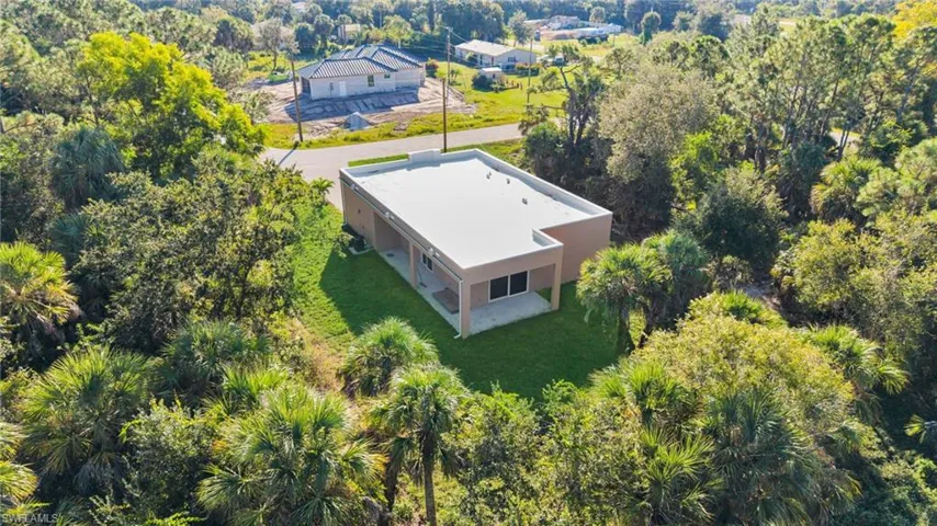 Aerial view of property and surrounding area with a tree filled landscape