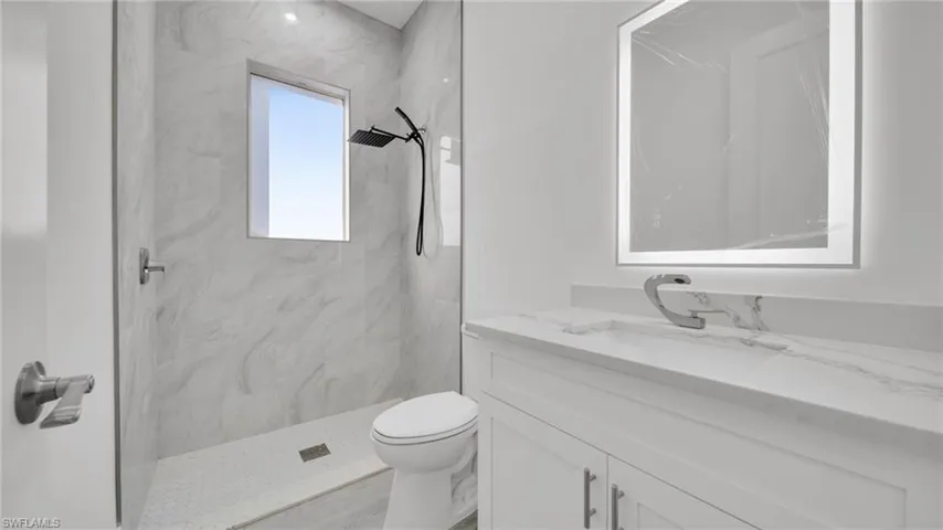 Full bath with a marble finish shower and vanity