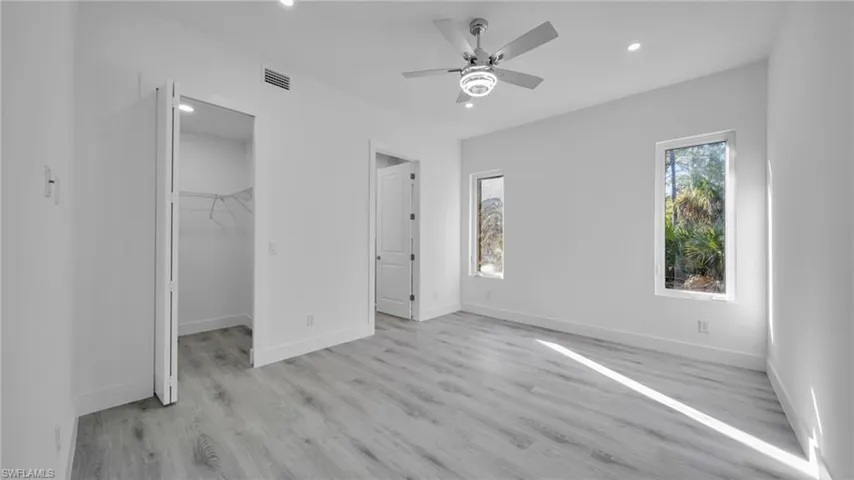 Unfurnished bedroom with light wood-style floors, recessed lighting, a walk in closet, and ceiling fan