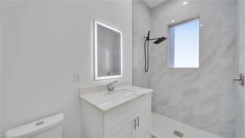 Bathroom with a marble finish shower and vanity