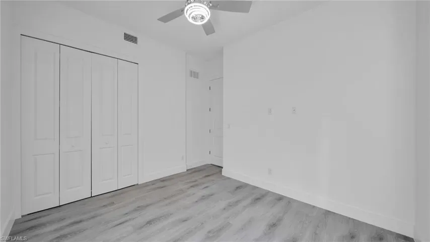 Unfurnished bedroom featuring light wood finished floors, a closet, and ceiling fan