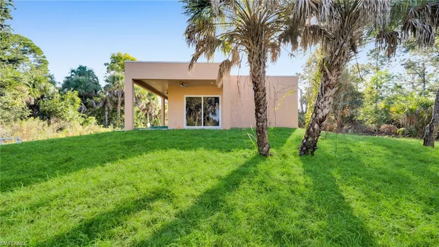 Rear view of house featuring a patio area, stucco siding, a yard, and a ceiling fan