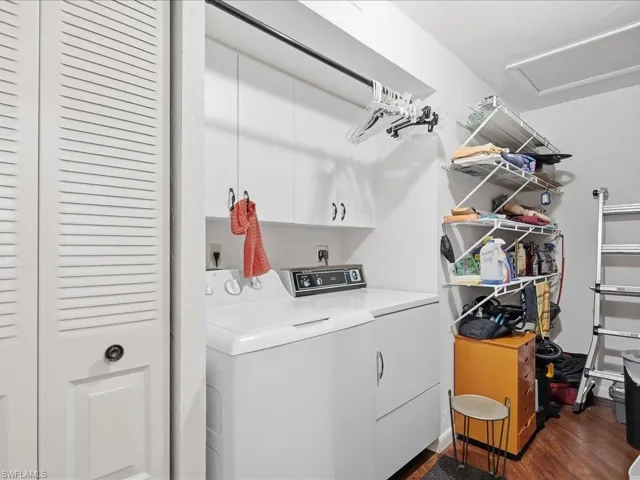 Washroom featuring washer and clothes dryer, dark wood finished floors, and attic access