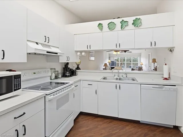 Kitchen featuring white cabinetry, white appliances, light countertops, under cabinet range hood, and a ceiling fan