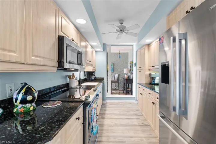 Kitchen with light wood-style flooring, recessed lighting, a ceiling fan, and appliances with stainless steel finishes