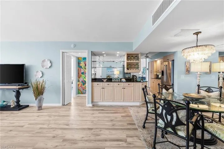 Dining area featuring baseboards, visible vents, a chandelier, and light wood finished floors