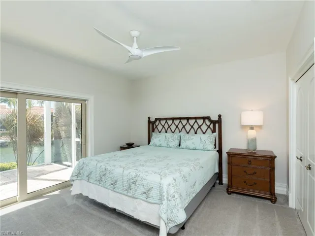 Carpeted bedroom with ceiling fan, a closet, and access to outside