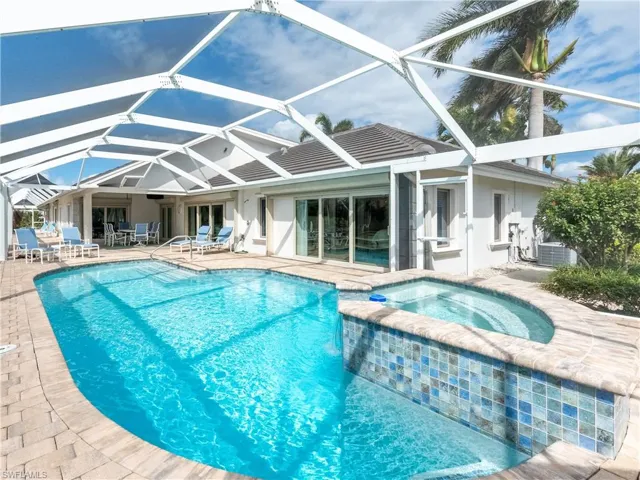 View of swimming pool featuring a patio, a lanai, and an in ground hot tub
